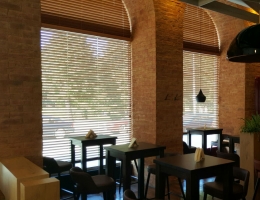 Semi-circular wooden blinds adorn the windows of a café in Latvia