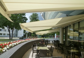 Plain and minimal awnings perfectly fit the modern facade of a building with a unique shape